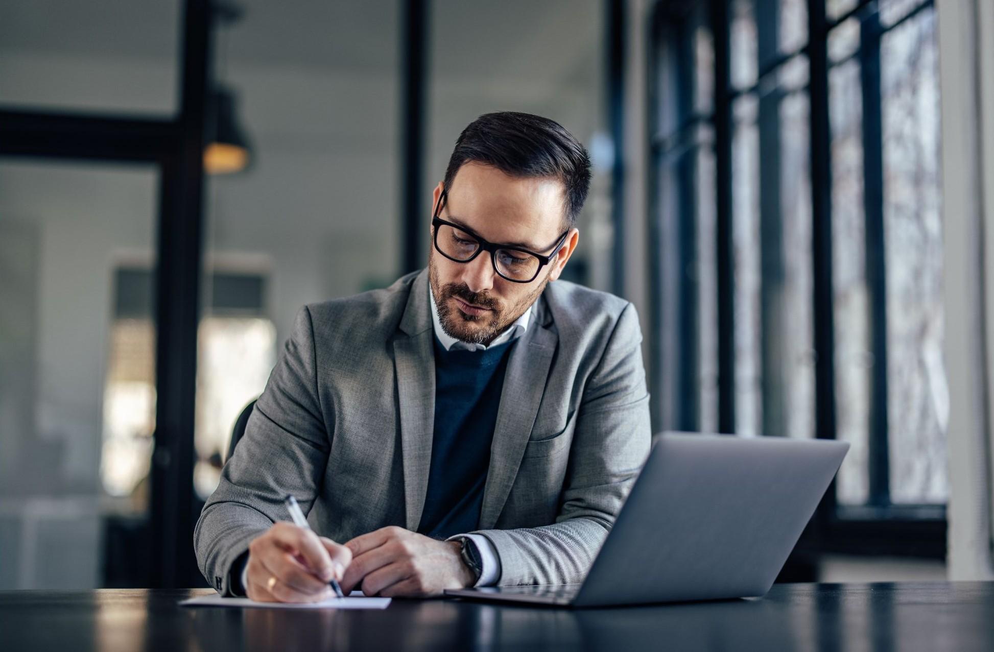 Forensic accountant reviewing financial documents at a desk.